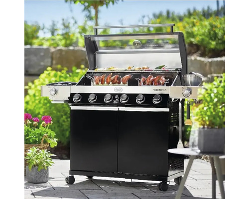 Gasbarbecue met gegrild voedsel op het rooster in de tuin