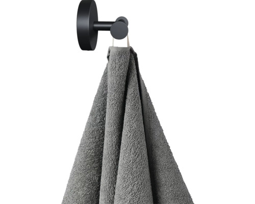 Grijze handdoek hangt aan een zwarte handdoekhaak