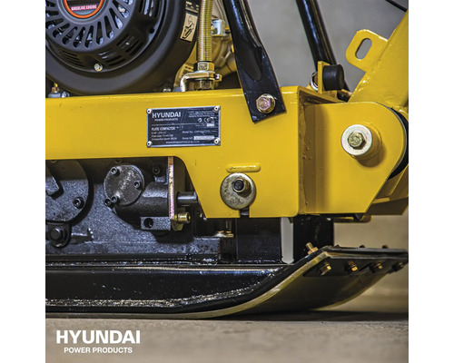 Detailopname van een trilplaat met motor en mechanische onderdelen.