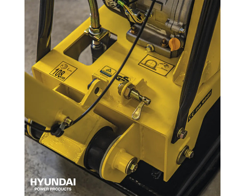 Detailopname van een trilplaat met waarschuwingsborden en GS-keurmerk