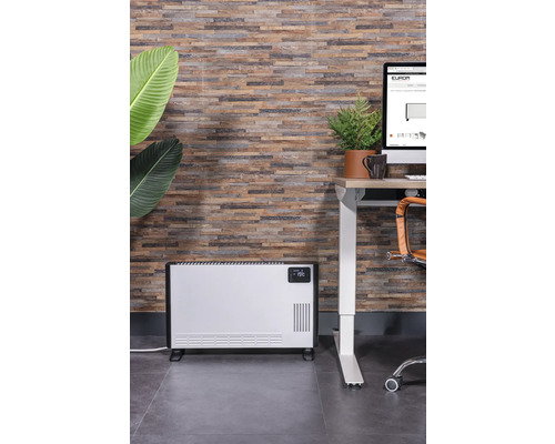 Scene met een elektrische radiator naast een bureau