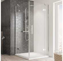 Douchecabine met glazen wanden en armaturen in een badkamer met tegelwand