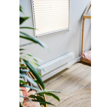 Scene met een witte wandconvector kachel in een kamer met een houten huisbed