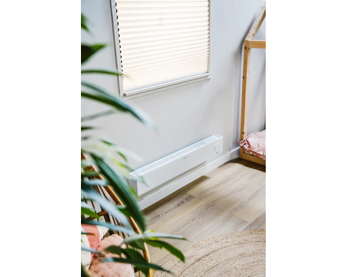 Scene met een witte wandconvector kachel in een kamer met een houten huisbed
