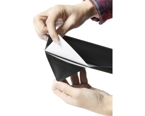 Persoon verwijdert beschermfolie van zelfklevende folie