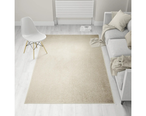 Beige tapijt in woonkamer met bank en stoel