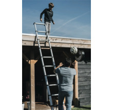 Buitenscène met een jongen op een telescopische ladder en een man met een voetbal.