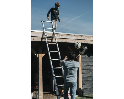 Buitenscène met een jongen op een telescopische ladder en een man met een voetbal.