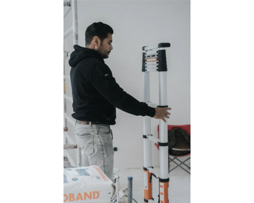Man houdt een telescopische ladder vast in een interieur