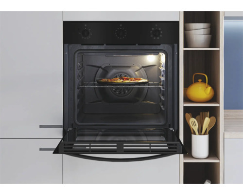 Ingebouwde oven met pizza op een rooster in een lichte keuken.