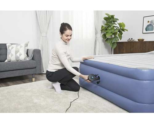 Vrouw pompt luchtbed op met een luchtpomp.