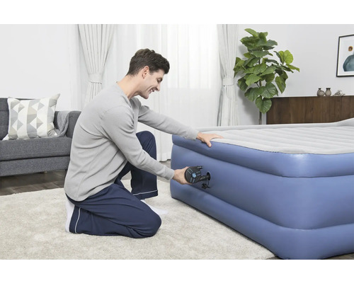 Man pompt een opblaasbaar matras op met een pomp