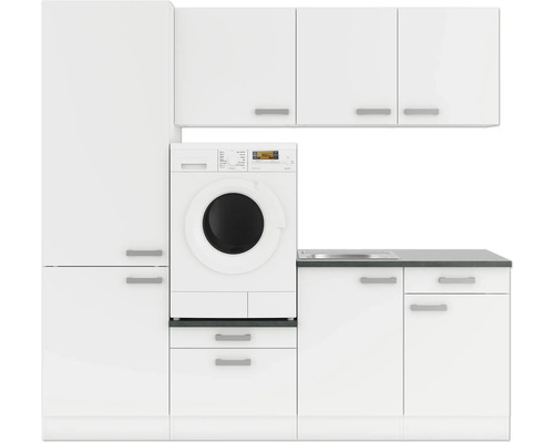 Wasruimte met wasmachine, gootsteen en kasten in wit