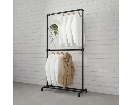 Zwart metalen buizen kledingrek met kleding en plant
