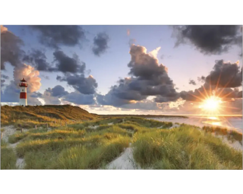 Landschap met vuurtoren in duingras onder een bewolkte hemel