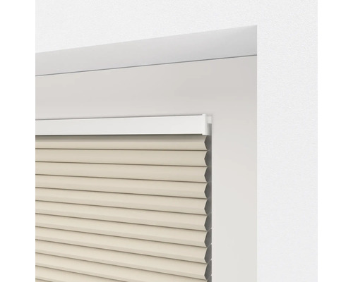 Gedetailleerde weergave van een beige plisségordijn in een raamkozijn.