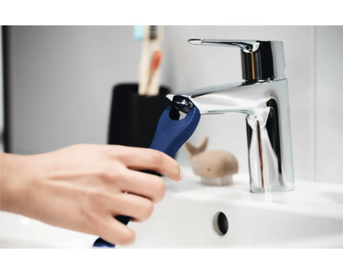 Kraanreiniging met gereedschap in de wastafel van de badkamer