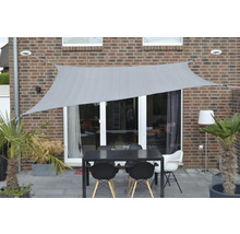 Terras met zonnescherm, tuintafel en stoelen voor een huis