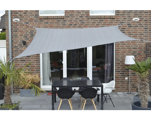 Terras met zonnescherm, tuintafel en stoelen voor een huis