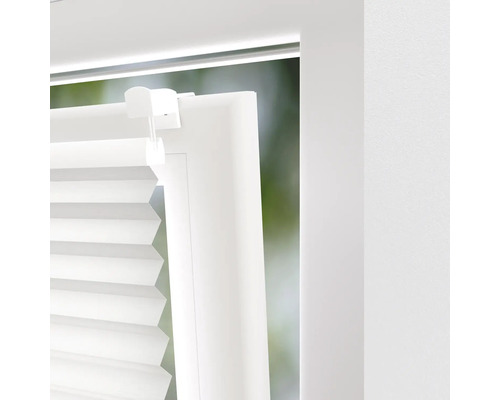 Gedetailleerde opname van een wit plisségordijn op een raam