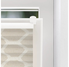 Detail van een beige plisségordijn met geometrisch patroon bij het raam