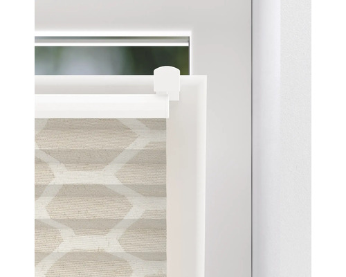 Detail van een beige plisségordijn met geometrisch patroon bij het raam