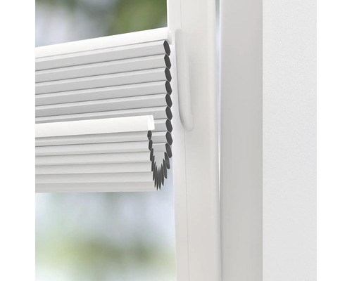 Close-up van een witte plisségordijn op het raam