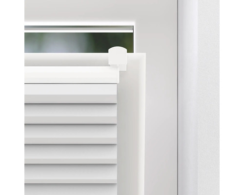 Detailopname van een wit plisségordijn op een raam