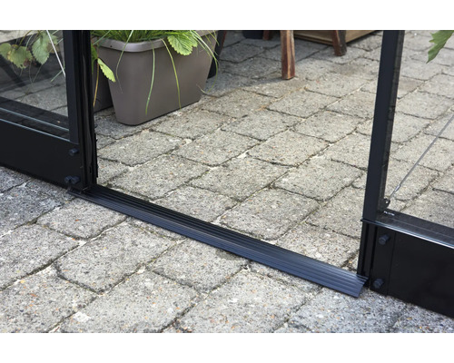 Detailopname van de grondstrip van een kas op straatstenen.