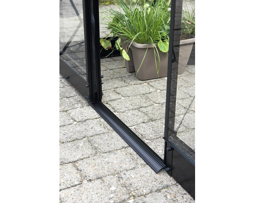 Detailopname van de aluminium basis van een kas op straatstenen