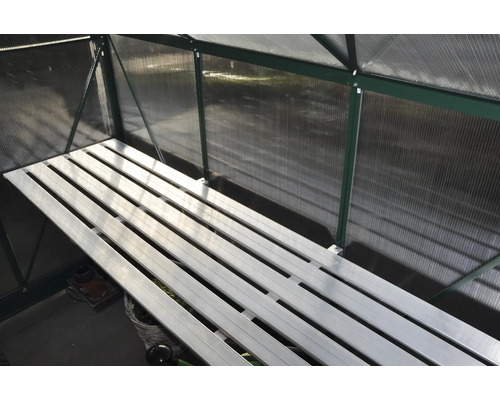 Binnenaanzicht van een kas met een plank.