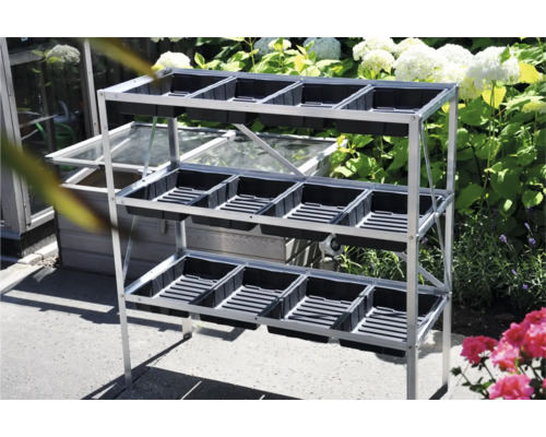 Plantentafel met drie niveaus en zwarte plantenbakken in de tuin