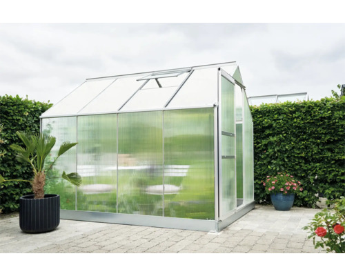 Kas met tafel en stoelen in de tuin