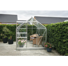 Tuinkas met aluminium frame, glazen wanden, planten en tuinmeubelen
