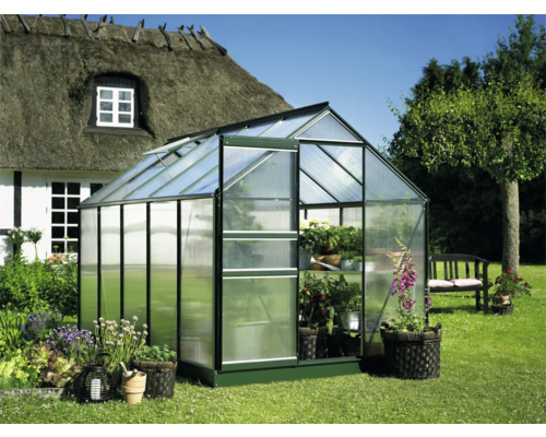 Serre in de tuin met open deur en planten