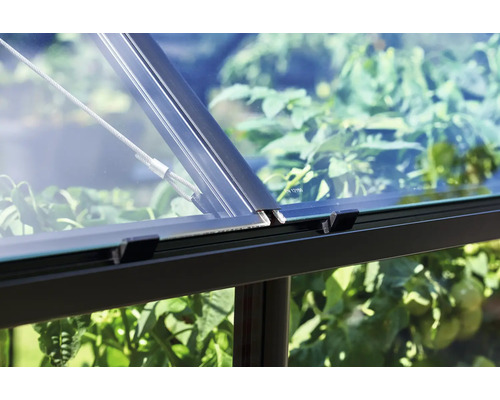 Detailopname van een kas met glas, frame en staalkabel