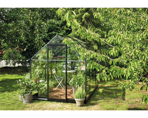 Glazen kas in de tuin met planten en zitje