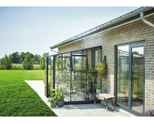 Aangebouwd glazen tuinkas aan huiswand met planten