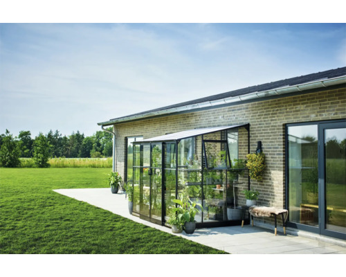 Kweekkas aan een huis met planten op een terras