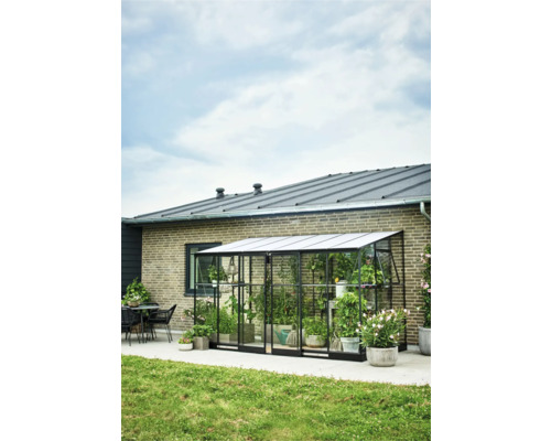 Metalen kas met planten voor een huismuur