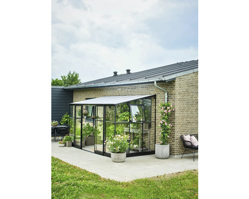 Aangebouwde kas met planten op een terras