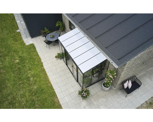 Bovenaanzicht van een serre met tuinmeubilair op een betegeld terras.