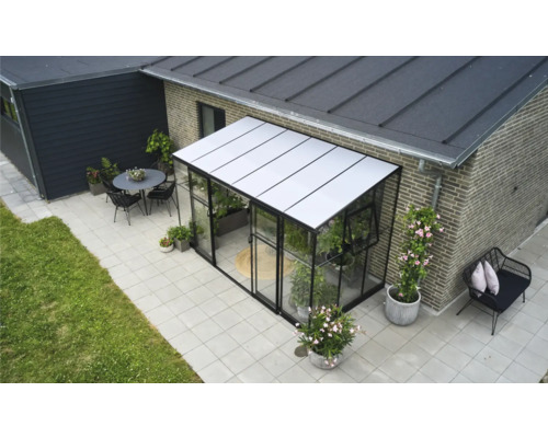 Buitenaanzicht van een serre met planten en tuinmeubelen op een terras