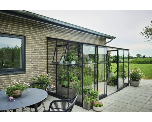 Aangebouwde kas met planten op terras