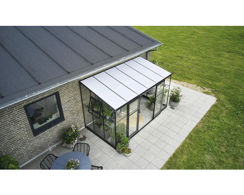 Serre aangebouwd aan een huis met terras en tuin