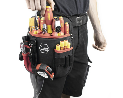 Persoon met gereedschapsgordel, gevuld met schroevendraaiers, tangen en een meetlint