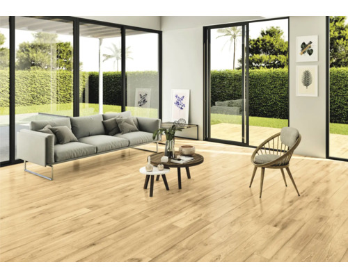 Lichte woonkamer met bank, stoelen en houten vloer