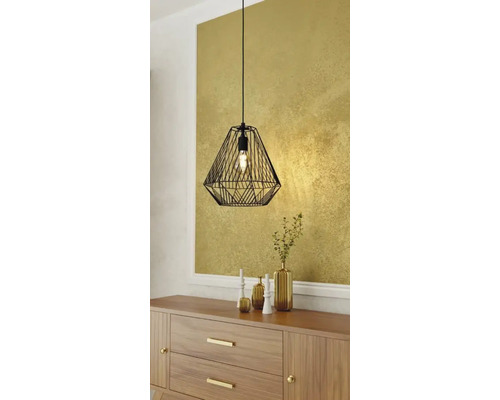Zwarte draadhanglamp boven houten dressoir met decoratie