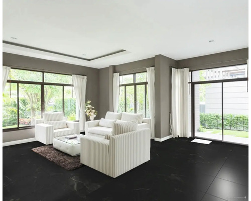 Woonkamer met zwarte vloertegels, witte meubels en grote ramen.
