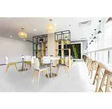 Lichte recreatieruimte met tafels, stoelen, planken en planten